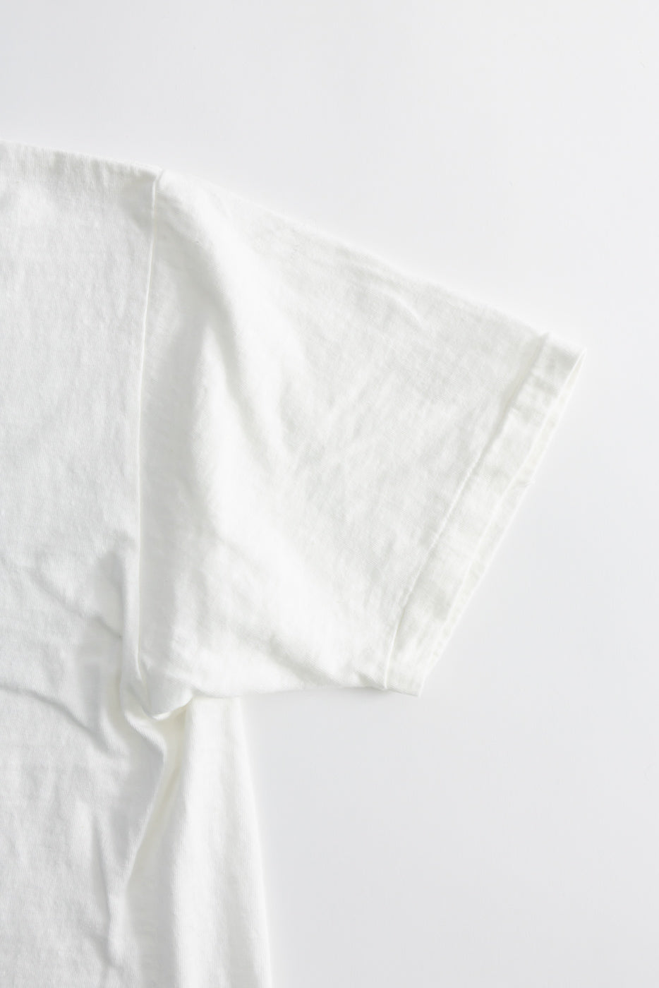Close-up of the 5.4oz Raffy Tenjiku Printed T-Shirt Grotius - Off White, showcasing its tubular construction, slub jersey texture, and seamless hem, reflecting Dant's focus on premium, heritage-inspired menswear.