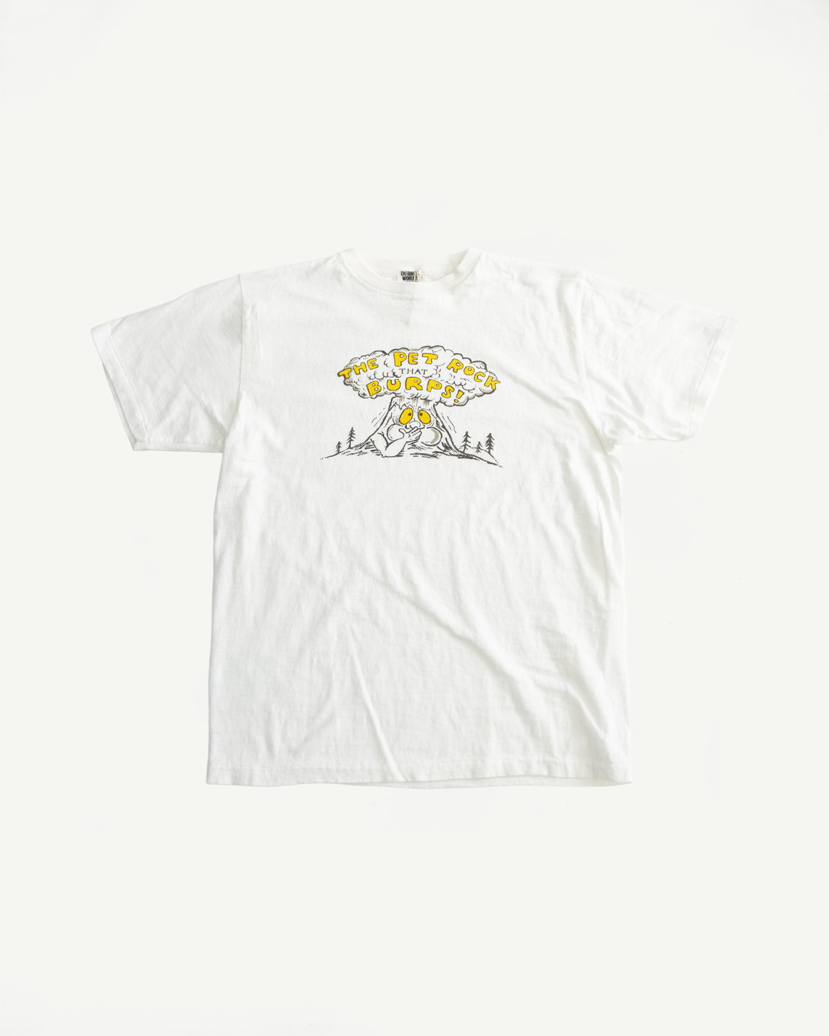 5.4oz Raffy Tenjiku Printed T-Shirt The Pet Rock - Off White, featuring a cartoon rock with googly eyes and THE PET ROCK THAT BURPS! text, showcasing a vintage-inspired design against a plain white tee.