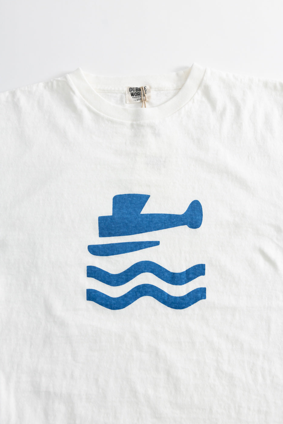 5.4oz Raffy Tenjiku Printed T-Shirt Seaplane - Off White: Features a blue submarine icon above wavy lines. Showcase of Japanese craftsmanship with vintage-inspired design from Dant's premium menswear collection.