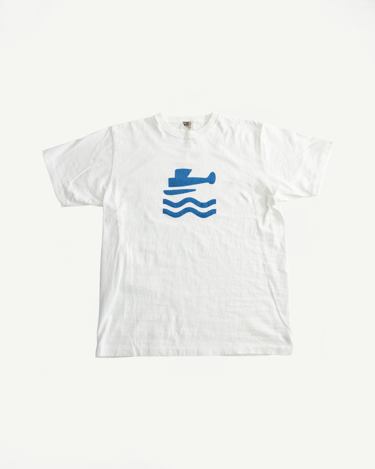 5.4oz Raffy Tenjiku Printed T-Shirt Seaplane - Off White, featuring a blue silhouette of a boat above wavy lines, showcasing slub jersey texture from organic Japanese cotton, inspired by vintage 1960s American tees.