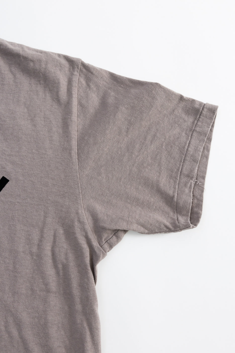 Close-up of the 5.4oz Raffy Tenjiku Printed T-Shirt Ski Inn in grey, highlighting its slub jersey texture, tubular knit construction, and seamless shoulder and sleeve detail.