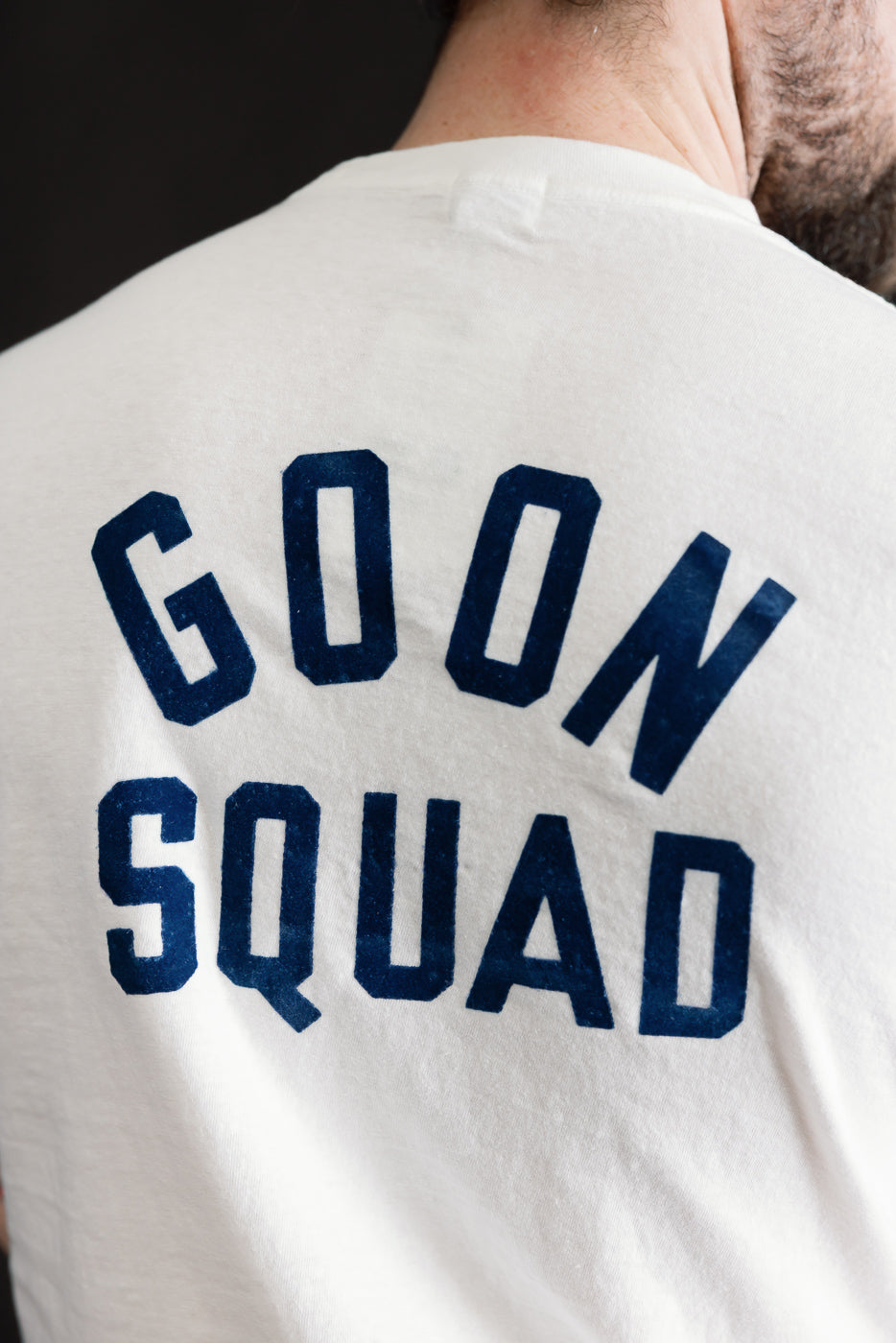 Upper back view of the 5.4oz Raffy Tenjiku Printed T-Shirt Ski Inn - Off White, featuring GOON SQUAD in navy block letters, highlighting the shirt's vintage-inspired design and premium construction.