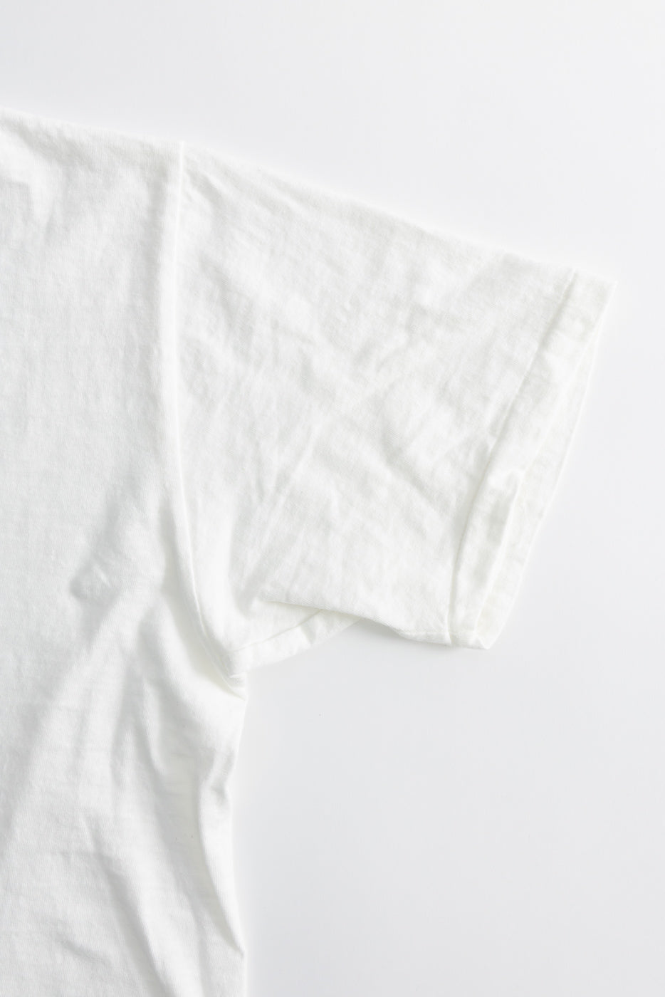DUBBLE WORKS Raffy Tenjiku T-Shirt Ski Inn - Off White, showcasing a right sleeve and torso. Crafted from 5.4oz slub jersey, emphasizing vintage-inspired tubular construction without side seams for a seamless appearance.