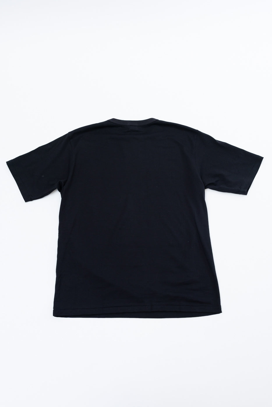 Black short sleeve t-shirt back view, flat lay, clean hem and crew neck detail