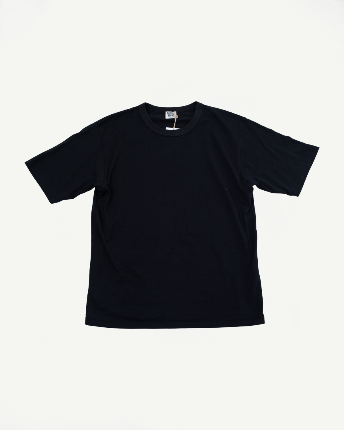 Front view of black crewneck t-shirt, flat lay, showcasing tag detail and clean hem