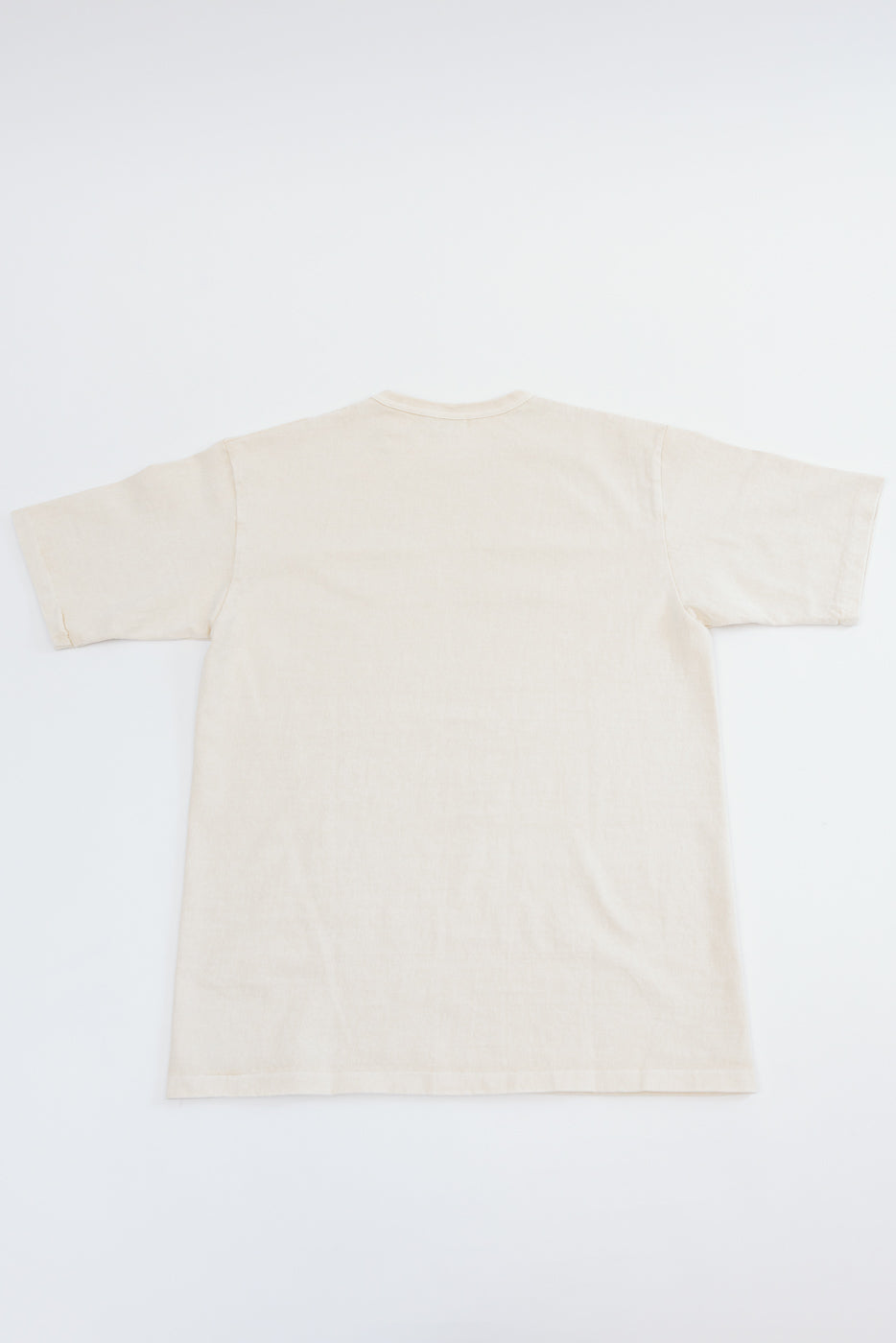 Flat lay back view of cream cotton t-shirt, showing clean hem and relaxed fit, no graphics