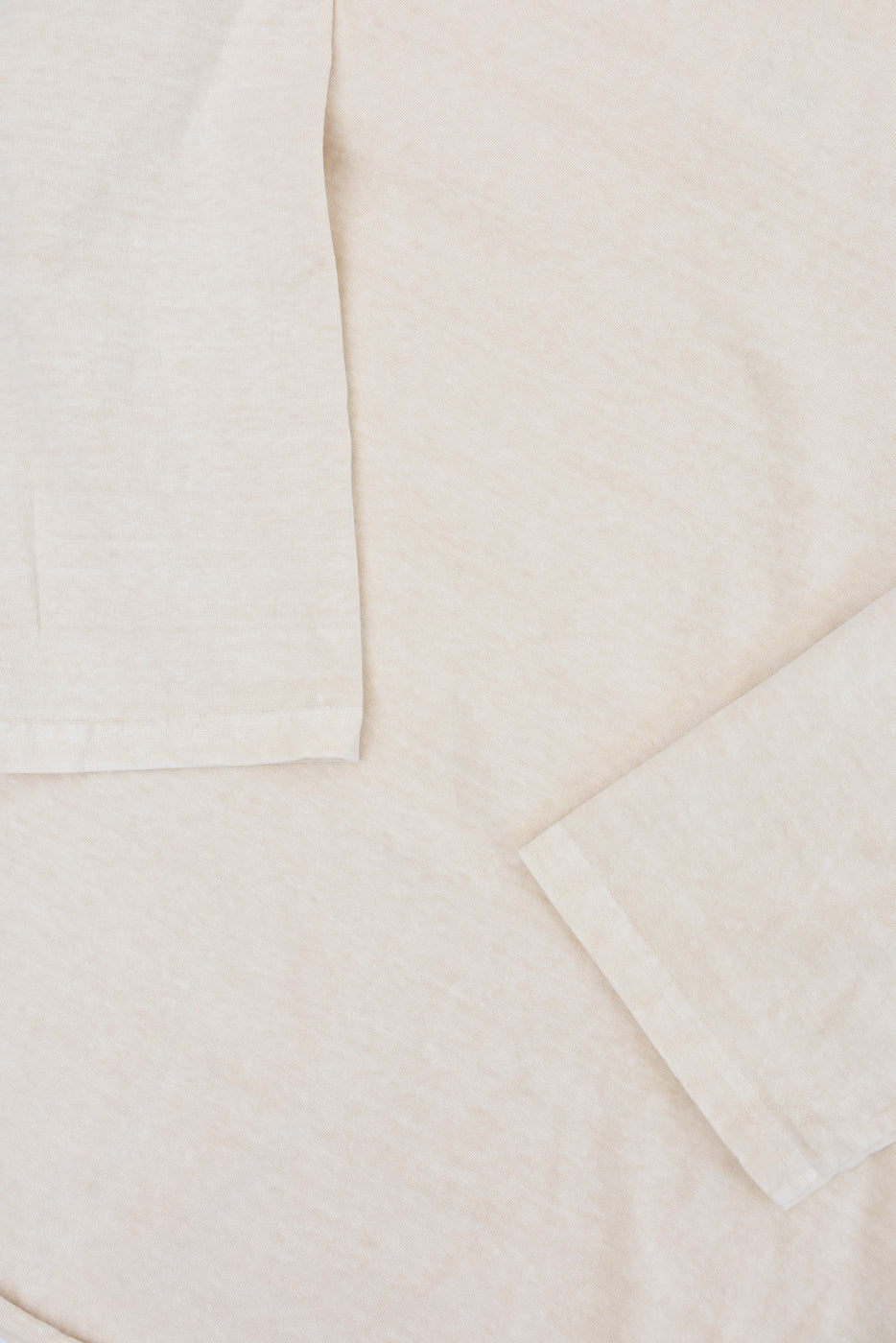 Close-up of cream long sleeve tee front, showing soft texture and clean hem details
