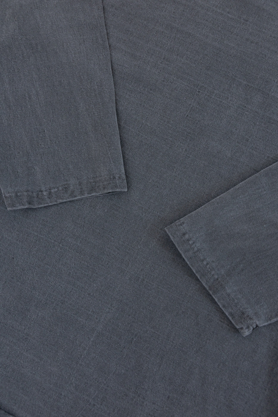 Close-up of dark gray shirt sleeves, showing hem stitching and fabric texture, front view