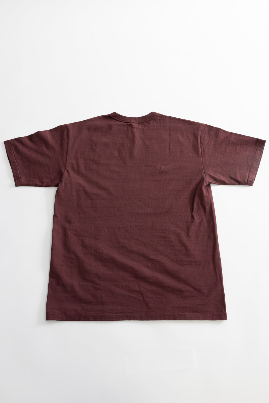 7.7oz - Fallen Cotton Midweight T-Shirt S/S - Bordeaux laid flat, showing its back. Made from recycled cotton slub jersey, it features a round body, binder neck, and single-stitched hem.