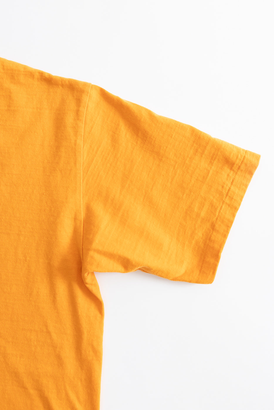 Bright orange 7.7oz Fallen Cotton Midweight T-Shirt S/S - Fade Orange, featuring a short-sleeve design, displayed flat on a white background, highlighting its recycled cotton slub jersey texture and classic construction.