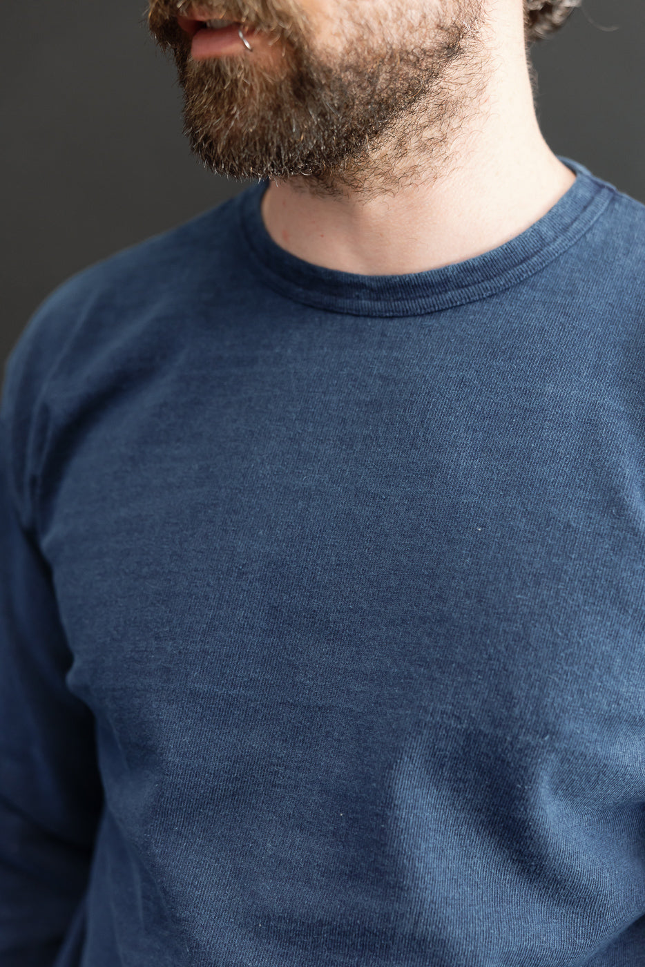 Close-up front view of navy long sleeve tee on male model, 5'9