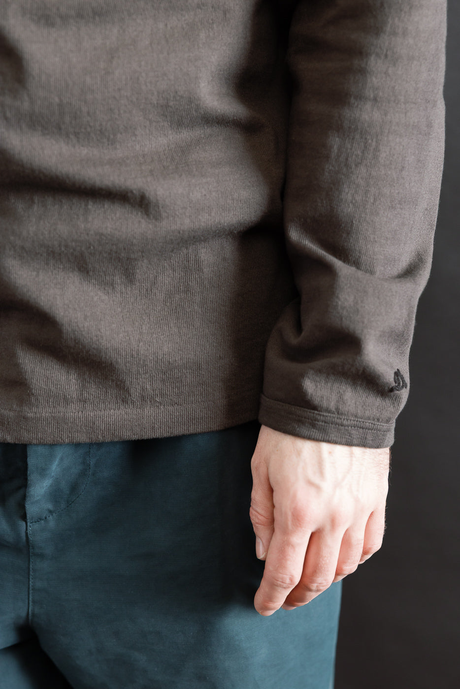 Close-up front view of male model’s right arm wearing heavyweight long sleeve tee cuff and hem; model is 5'9