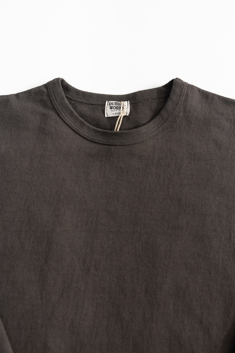 Close-up of the front neck and chest area of a heavyweight long sleeve tee, showing ribbed collar and fabric texture.