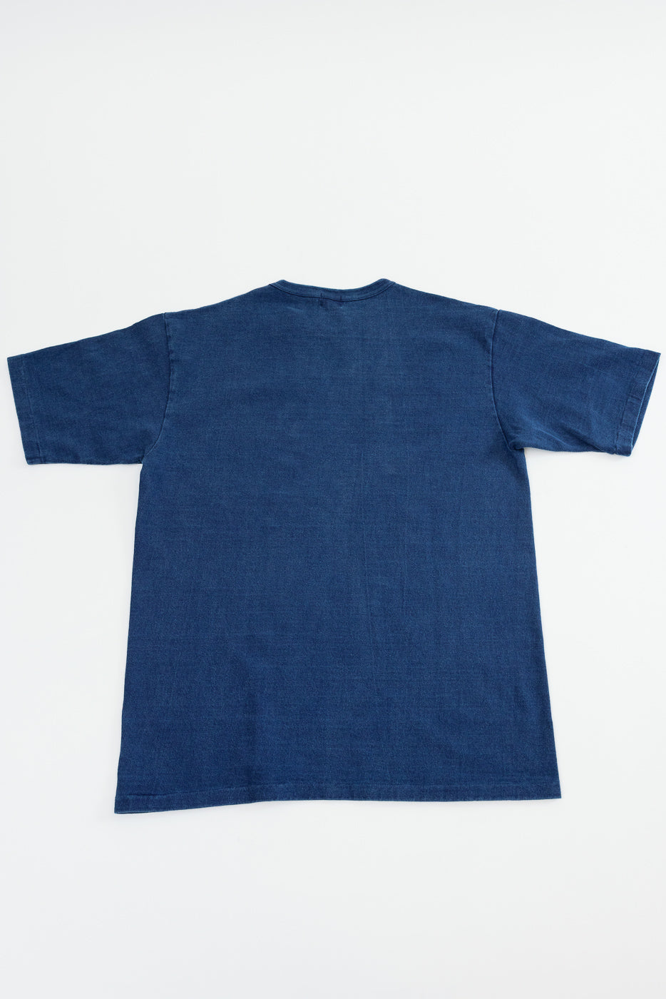 Back view of indigo denim t-shirt, flat lay, showcasing fabric texture and hem detail