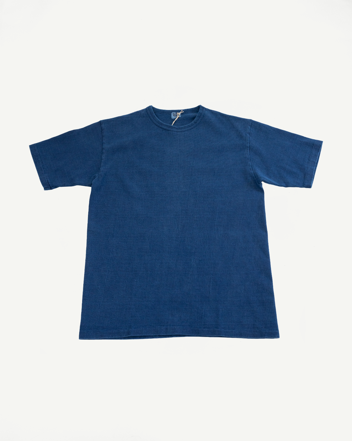 Front flat lay of indigo blue short-sleeve t-shirt with crew neck and visible tag detail.
