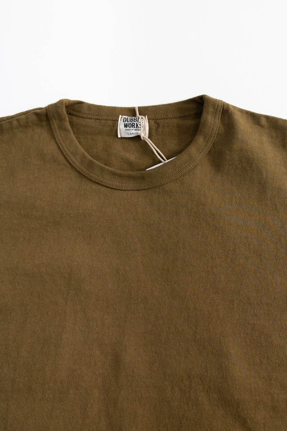Close-up front view of khaki heavyweight tee, showing ribbed crewneck collar and fabric texture.