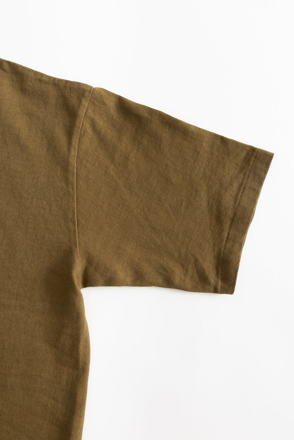 Close-up of right sleeve and shoulder seam on heavyweight khaki t-shirt, front view.