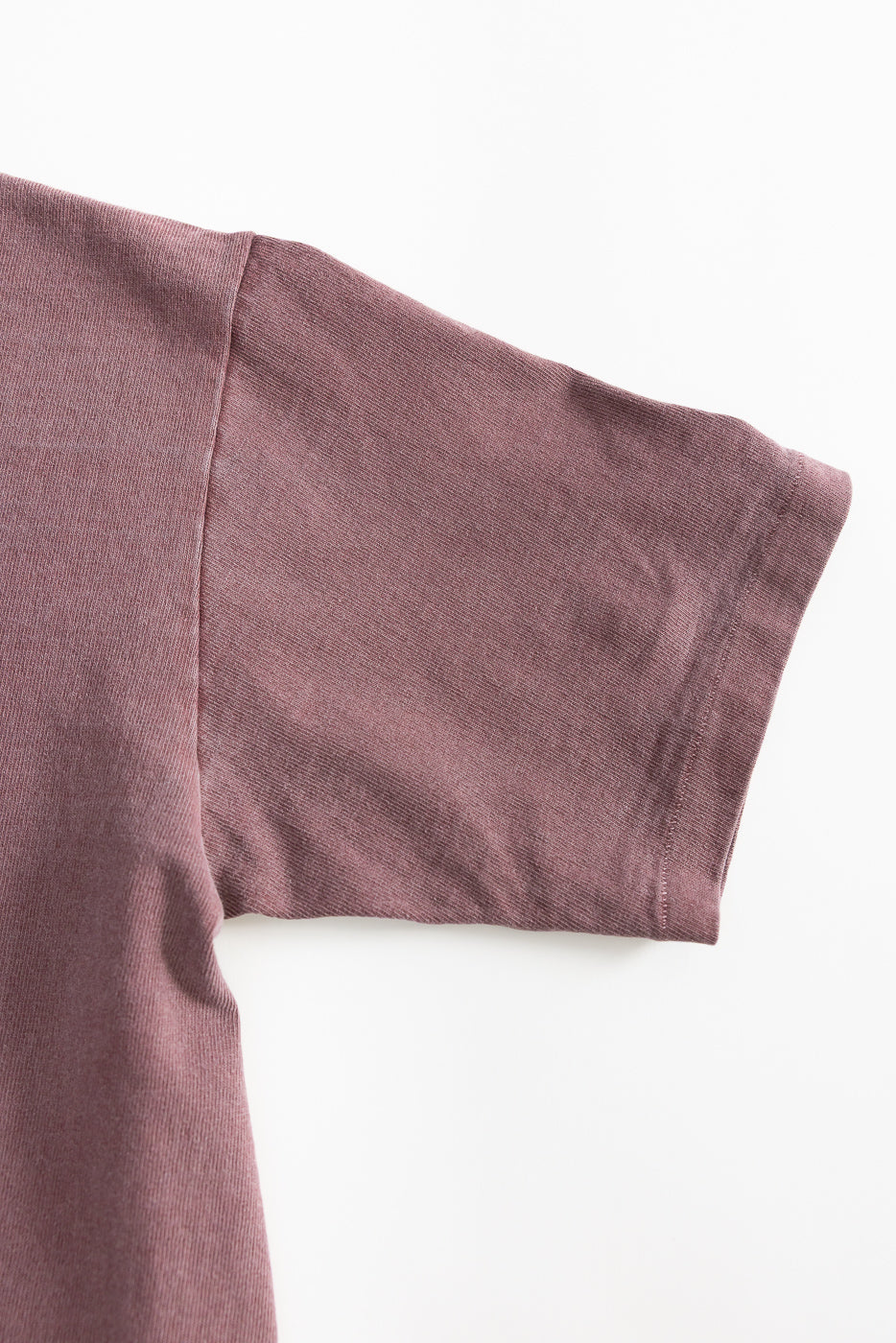 Close-up of right sleeve and side seam on front of heavyweight bordeaux pigment-dyed tee.