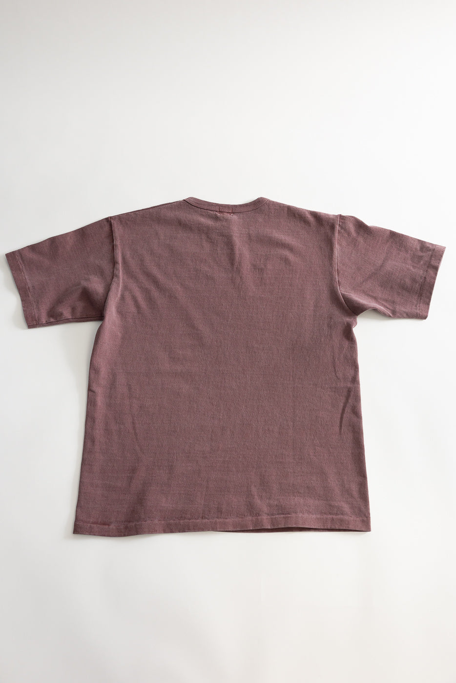 Flat lay of heavyweight bordeaux pigment dyed tee showing back side, short sleeves, straight hem.