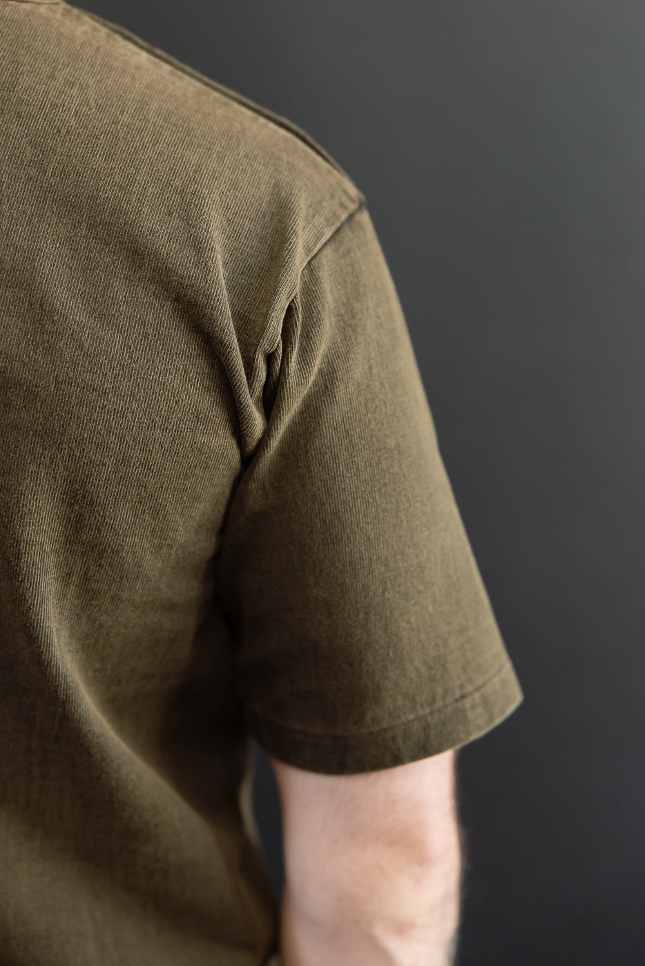 Close-up side view of olive green t-shirt on male model, 5'9