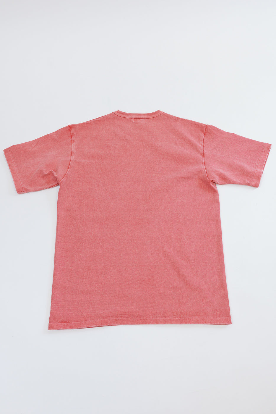 Flat lay back view of coral short sleeve tee, showcasing relaxed fit and clean hem detail