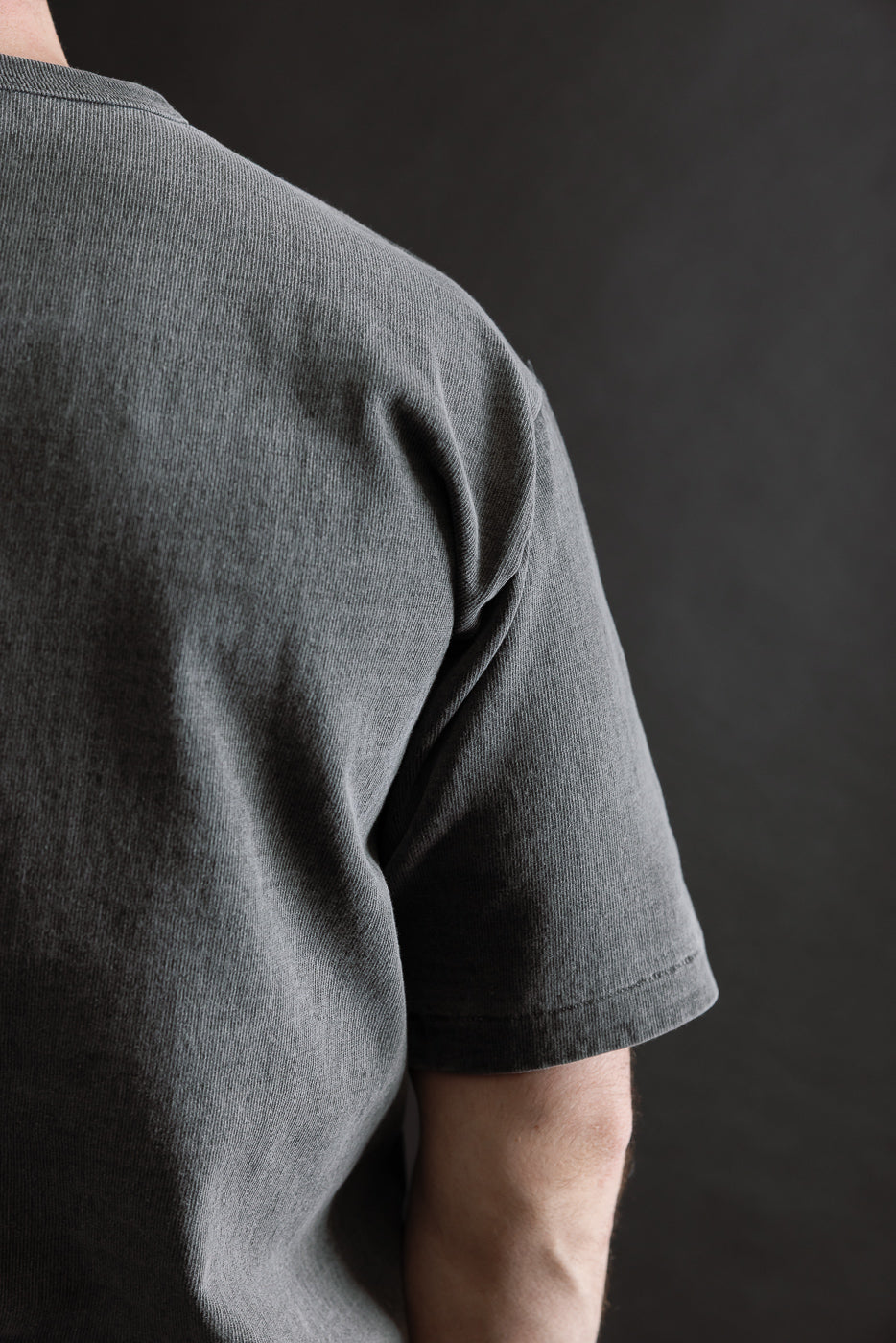 Close-up of back and shoulder of heavyweight pigment-dyed tee on male model, right side.