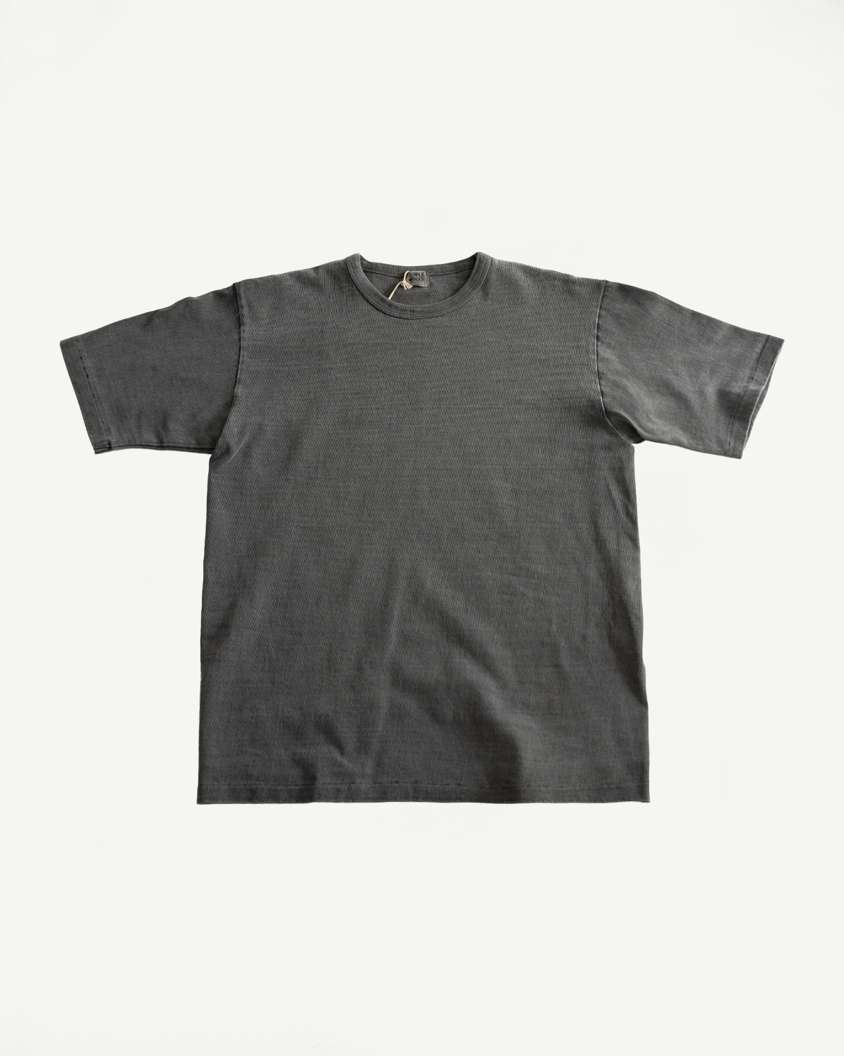Flat lay of pigment-dyed heavyweight tee, front view, showing crew neck and short sleeves.