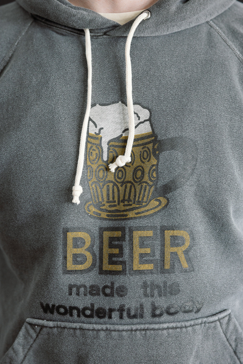 Close-up front of men's faded graphic hoodie, beer mug print, model is male, 5'9