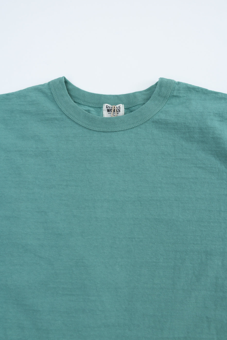 Close-up front of Dubble Works emerald green midweight tee, showing crew neck and fabric texture.