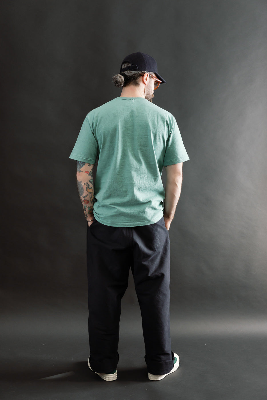 Male model 5'9 165lbs athletic build wearing emerald green tee, back view full body