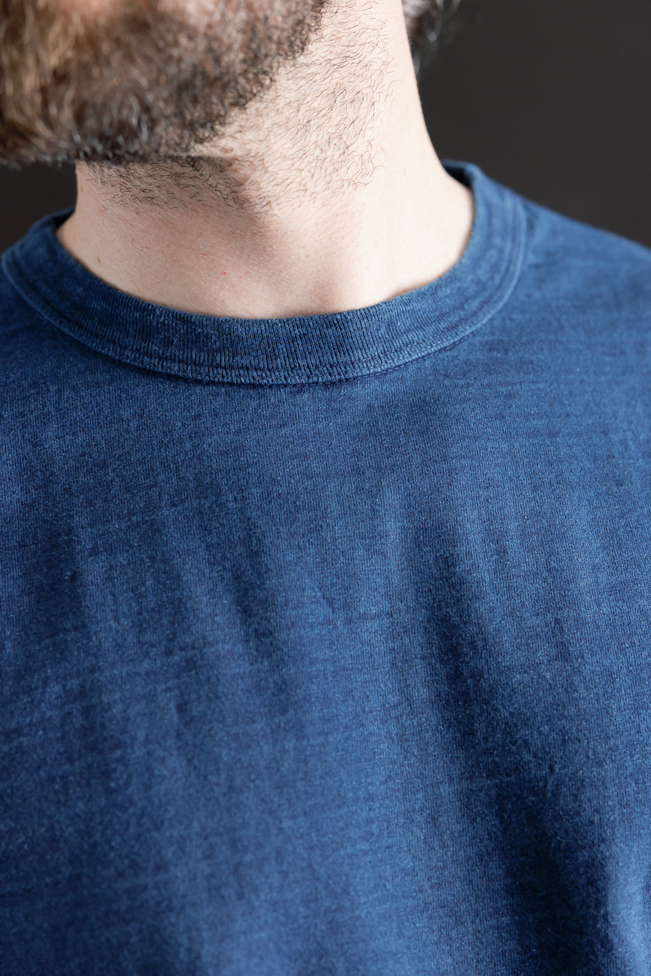 Close-up front of indigo midweight cotton tee, ribbed collar, worn by male model 5'9