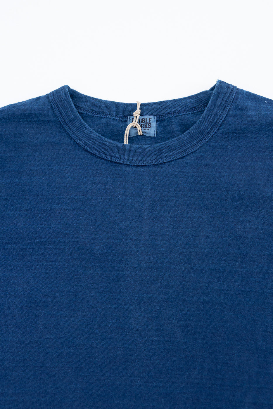 Close-up front of Dubble Works indigo cotton tee, showing crew neck, collar, and fabric texture.