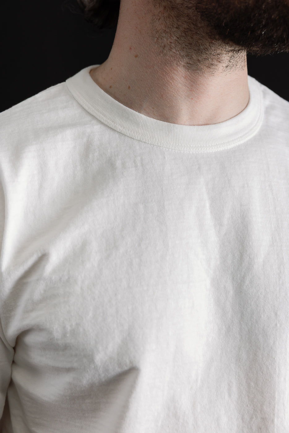 Close-up of off-white Dubble Works cotton t-shirt front, male model, showing fabric texture and crew neck