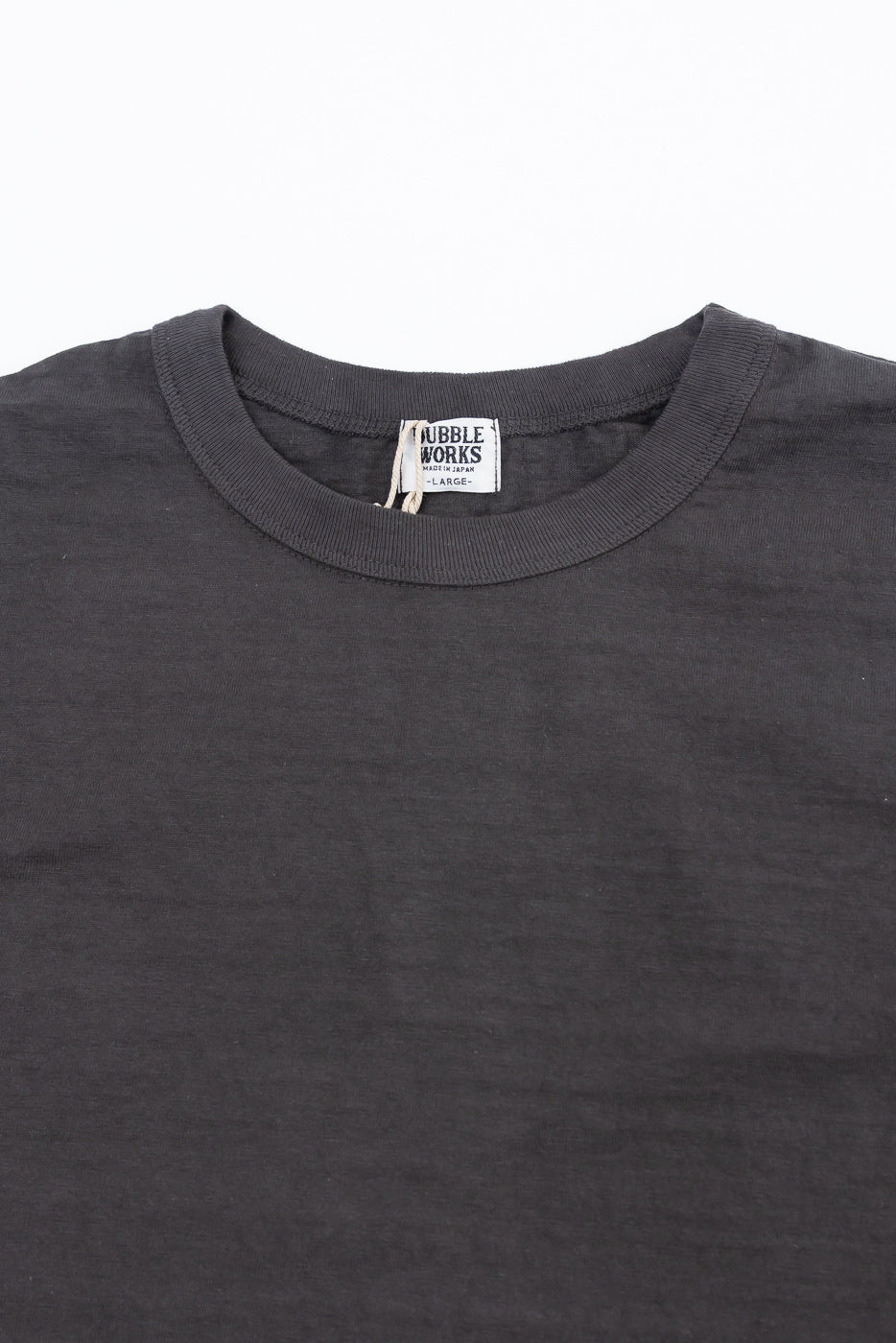 Close-up of Dubble Works Fallen Cotton Midweight Tee front, showing collar, fabric texture, and neck tag detail, contemporary casual apparel at Dant.