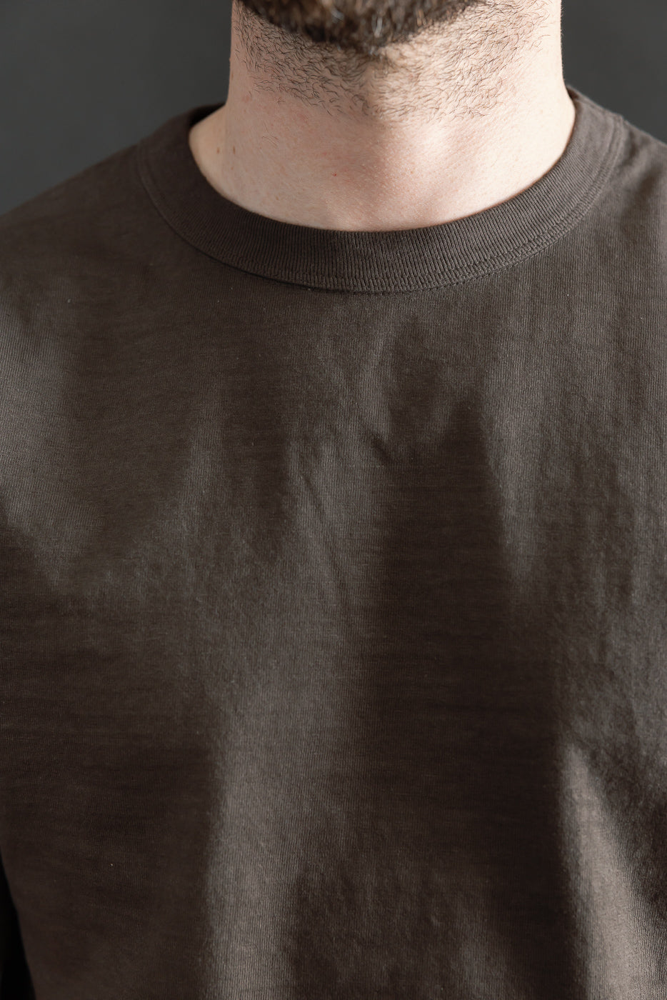 Close-up of front neckline and collar texture on Dubble Works Sumikuro cotton tee, shown on male model, 5'9