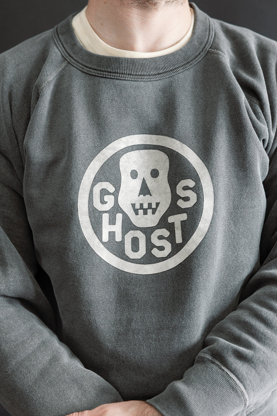 Close-up front view of faded print crewneck sweatshirt on male model, 5'9