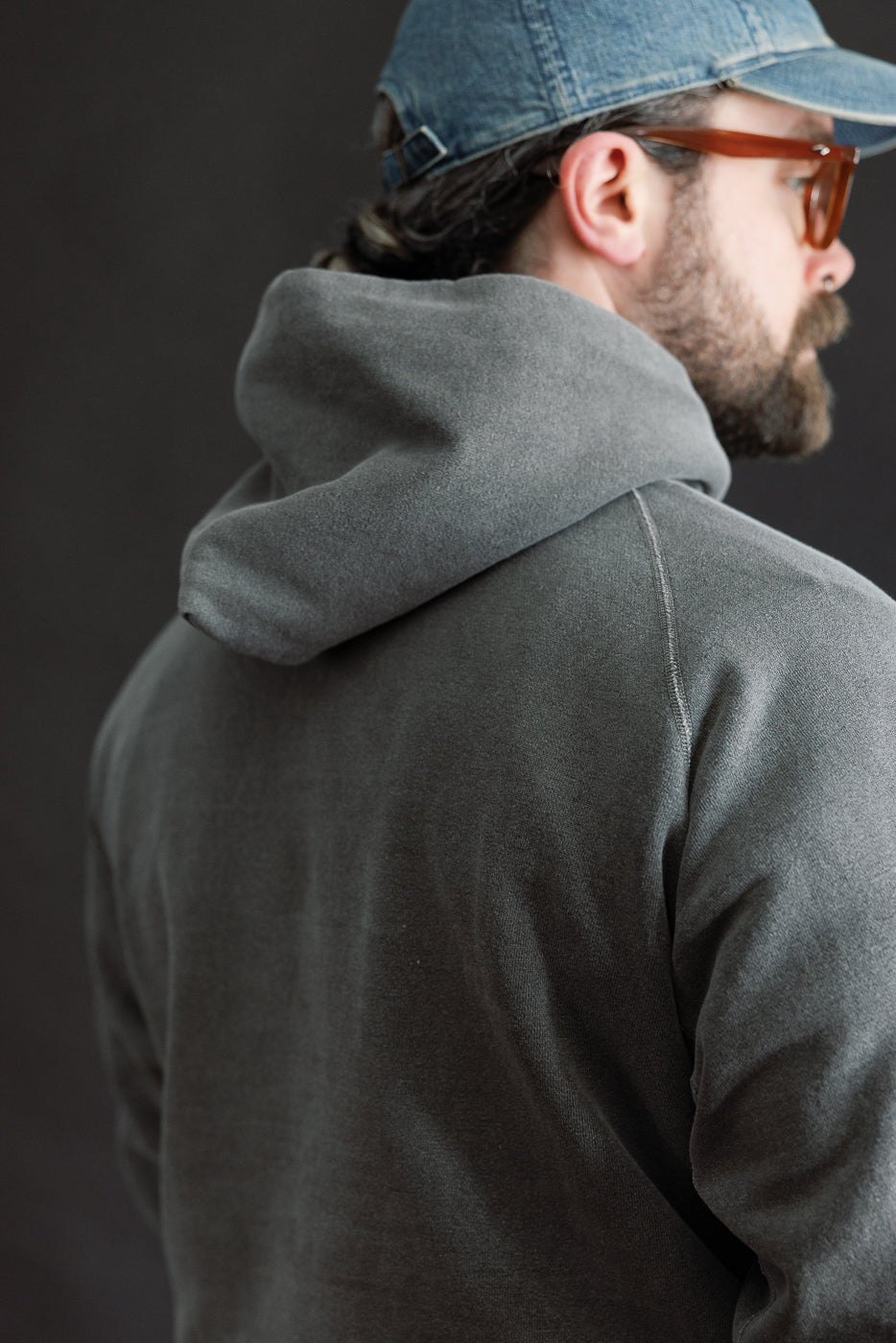 Close-up of back and hood detail, faded black hoodie on male model 5'9