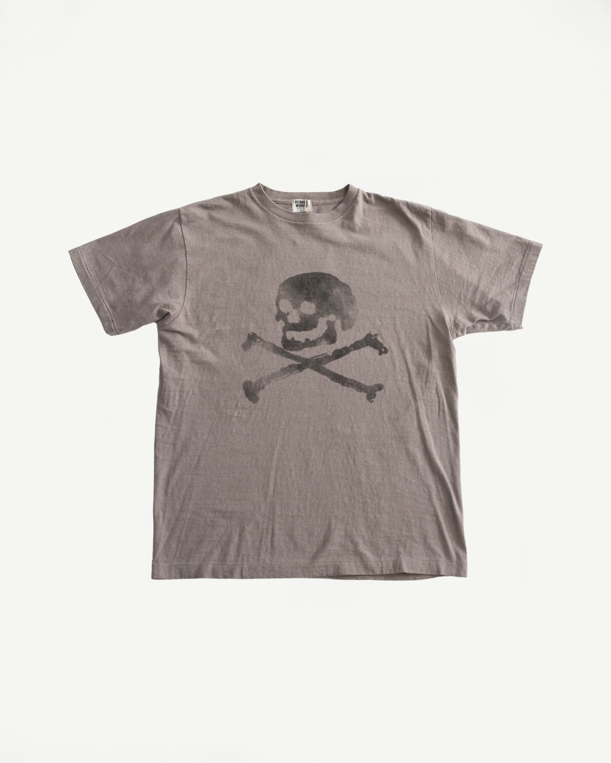 5.4oz Raffy Tenjiku Printed T-Shirt Skull & Crossbone - Grey features a vintage-inspired skull-and-crossbones graphic on a gray, short-sleeved, seamless tubular knit, crafted from textured Japanese organic cotton.