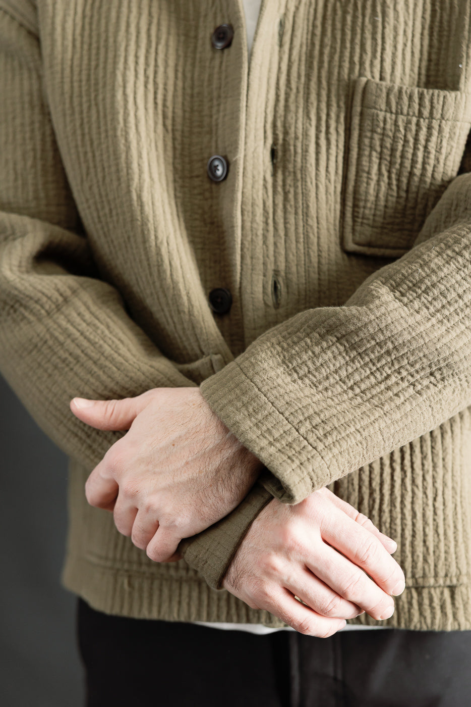 Close-up front of men's fossil green jacquard shirt on male model, 5'9, 165lbs, athletic build, showing button detail, textured fabric, and chest pocket.