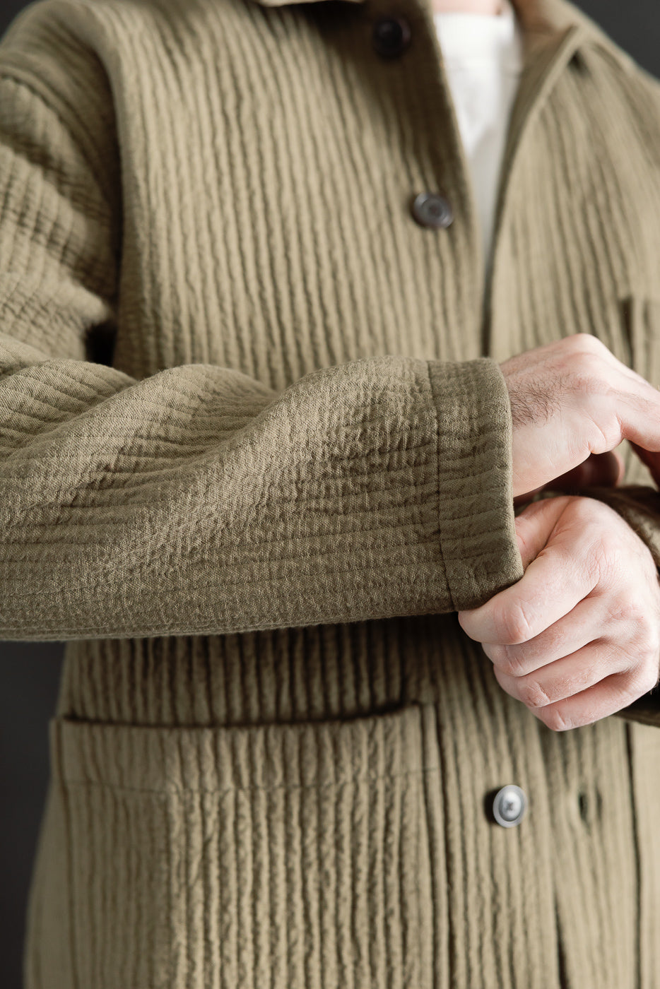 Close-up of men's fossil green jacquard shirt sleeve and front buttons, model is male, 5'9