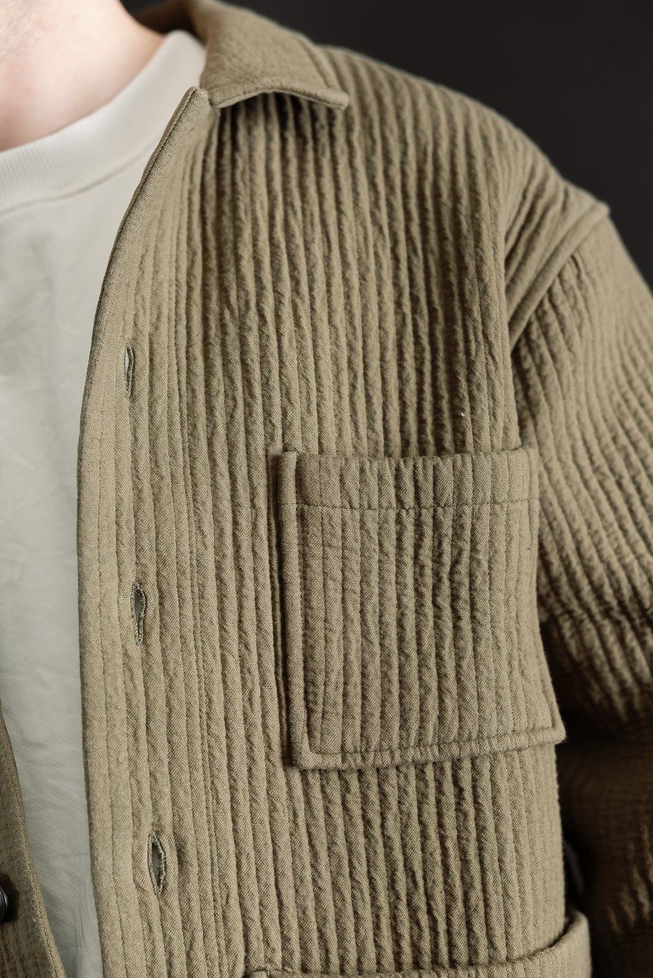 Close-up of men's fossil green jacquard shirt, front left chest pocket, textured fabric, on 5'9