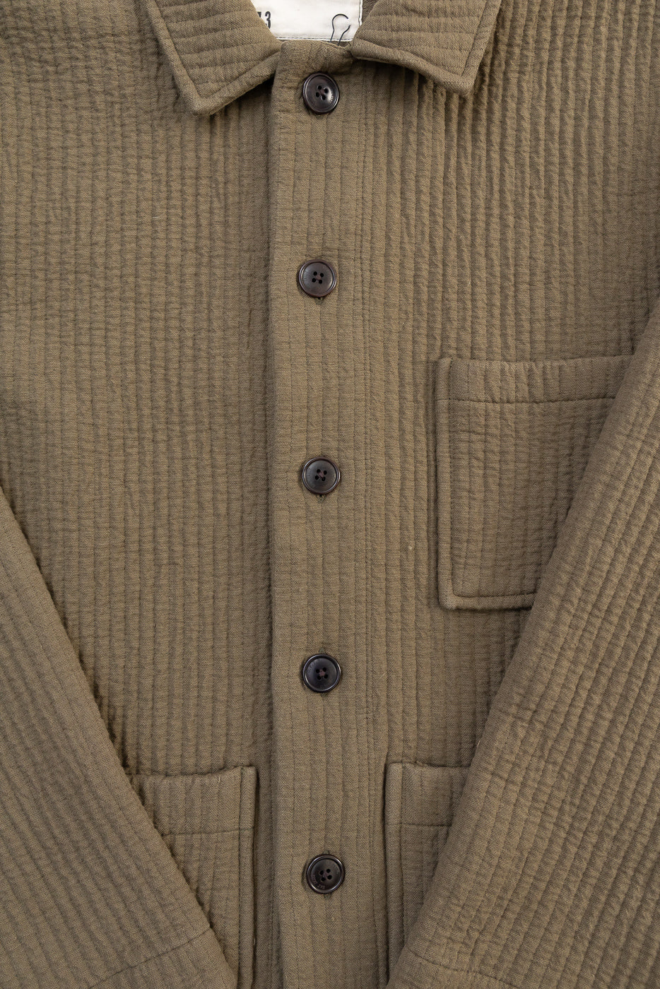 Close-up of front Eat Dust Cana Shirt in fossil green jacquard, showing buttons, textured fabric, pockets, and collar