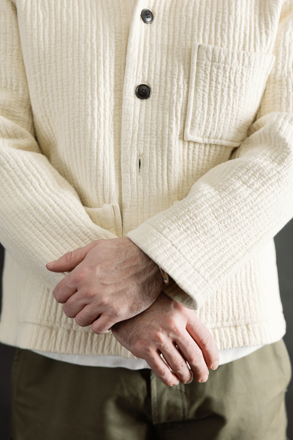 Close-up front of men's wheat jacquard shirt, buttons, patch pocket, textured fabric, on 5'9
