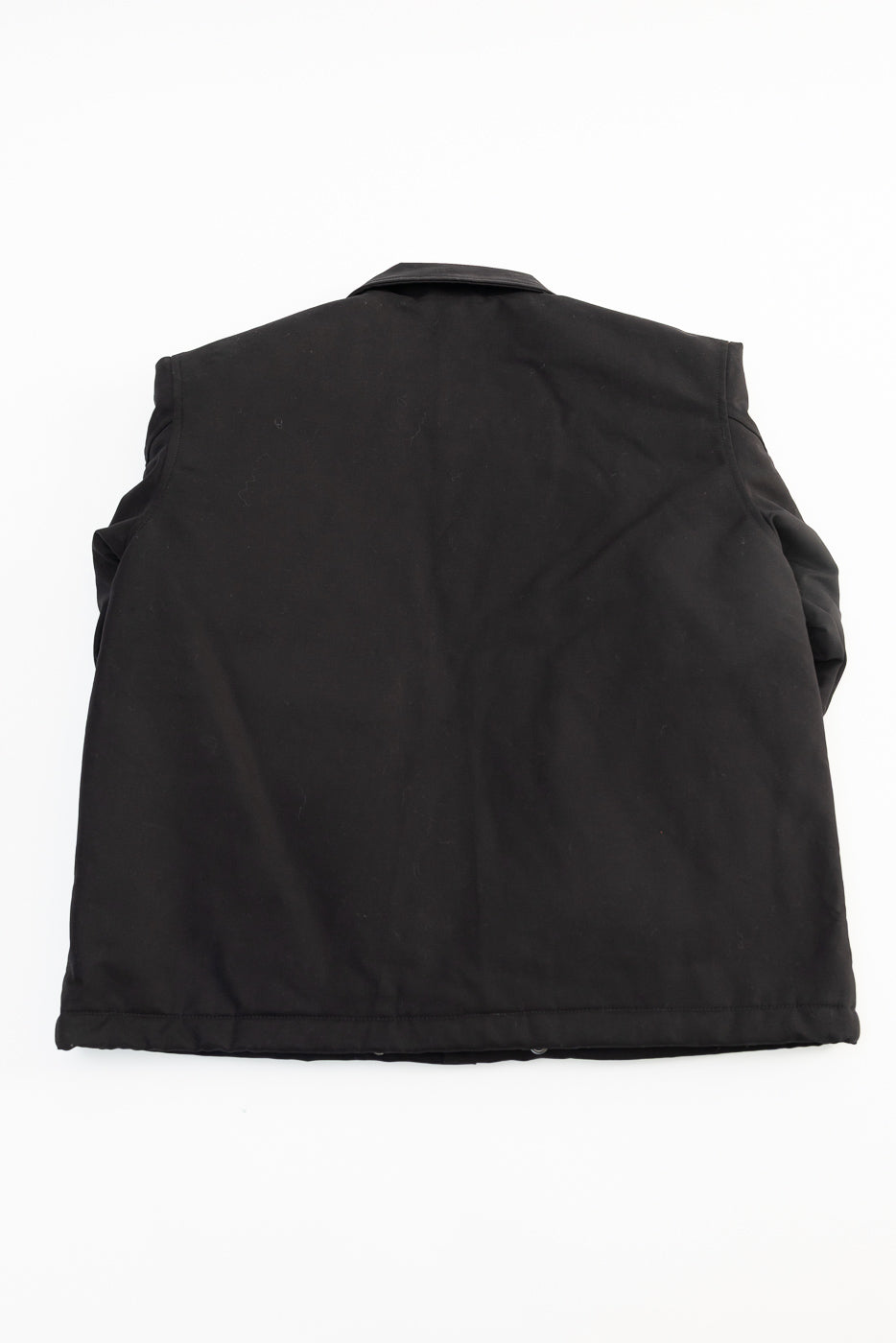 Flat lay of Eat Dust black cotton jacket, back view, showing fabric and back hem details from Dant.