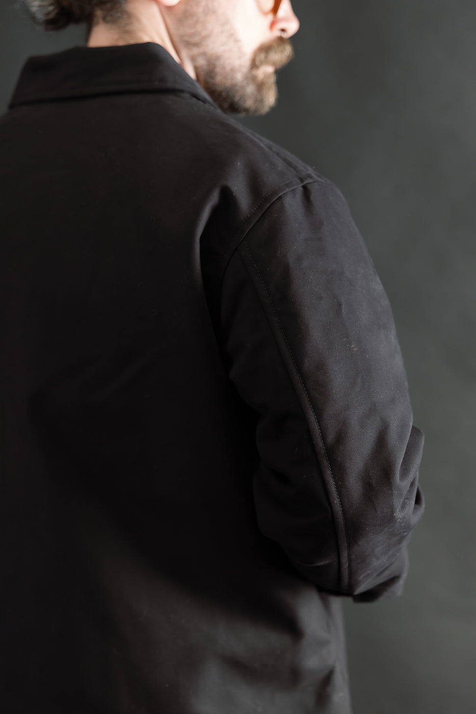 Close-up of back and left sleeve of men's black Nebraska cotton jacket on 5'9