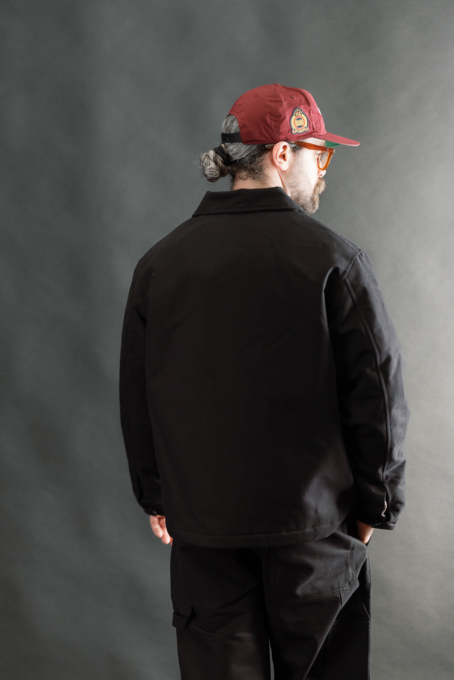 Male model 5'9 165lbs athletic build wearing Eat Dust Dago Jacket in black, back view full body