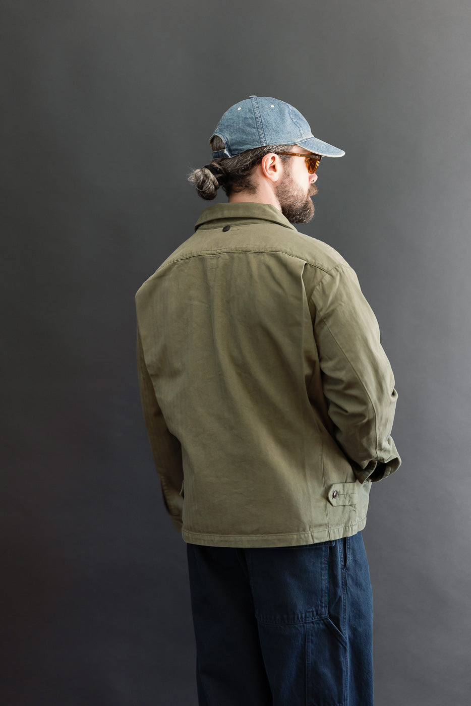 Back view of an olive green casual jacket on a 5'9