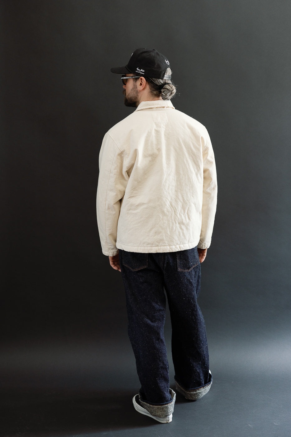 Male model 5'9 165lbs athletic build wearing ecru jacket, back view full body shot