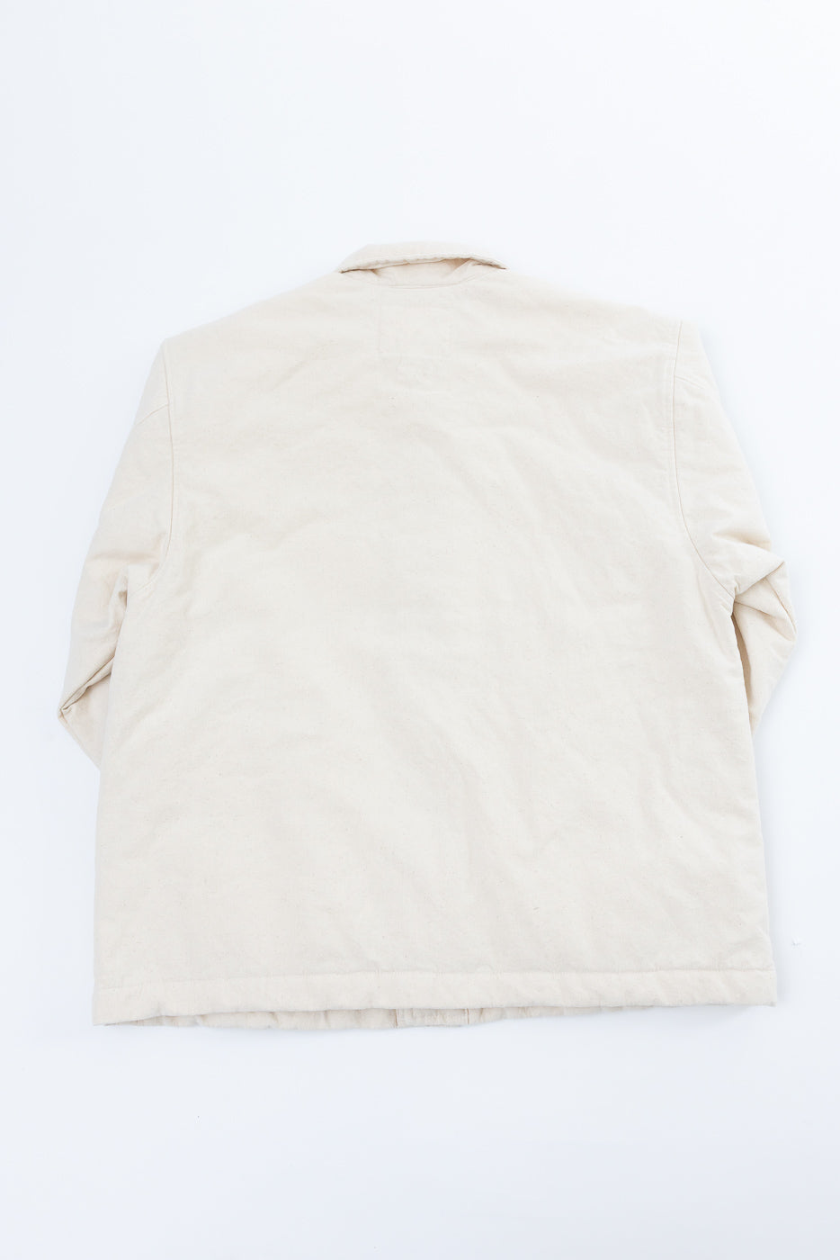 Flat lay of ecru cotton jacket, back view, showing collar and straight hem detail.