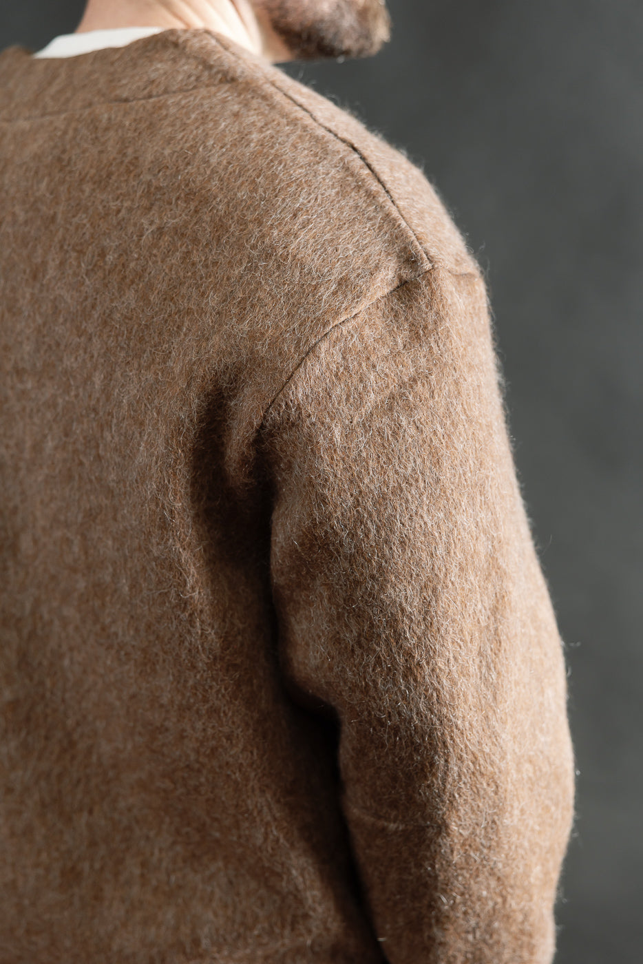 Close-up of men's java brown mohair fleece cardigan shoulder and sleeve, model 5'9